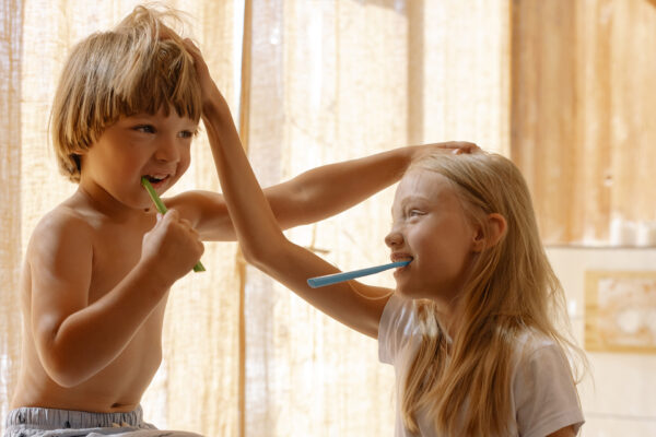 two children brushing their teeth